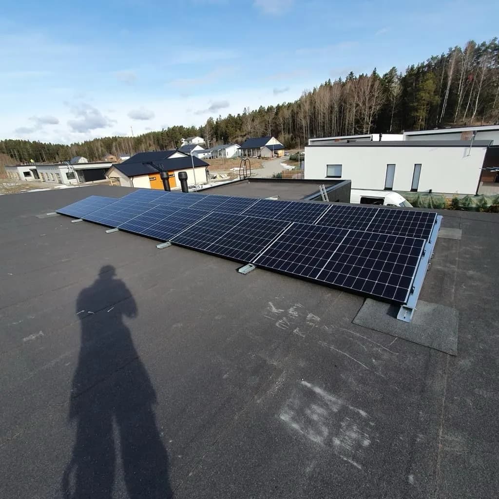 Lähikuva tyylikkäästä, modernista aurinkopaneelista eloisan violetin taustan edessä.