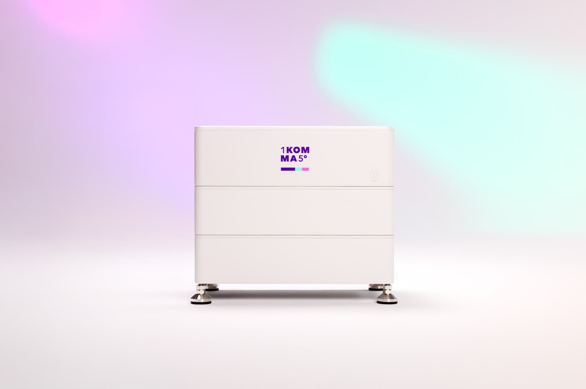 Valkoinen aurinkoenergian varastointiyksikkö, jossa on 1KOMMA5°-logo, seisoo metallijaloilla liukuvärisellä taustalla, jossa on pinkkejä ja turkooseja sävyjä.