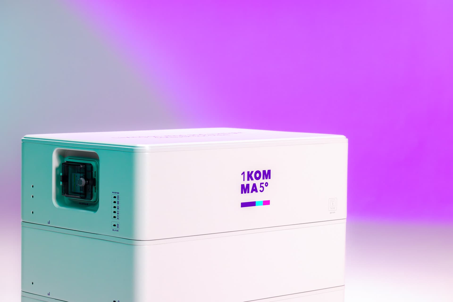 Valkoinen suorakaiteen muotoinen akkulaite, jossa on heijastavalla pinnalla merkintä "1KOMMA5°", liukuvärjätyllä violetilla ja sinivihreällä taustalla.