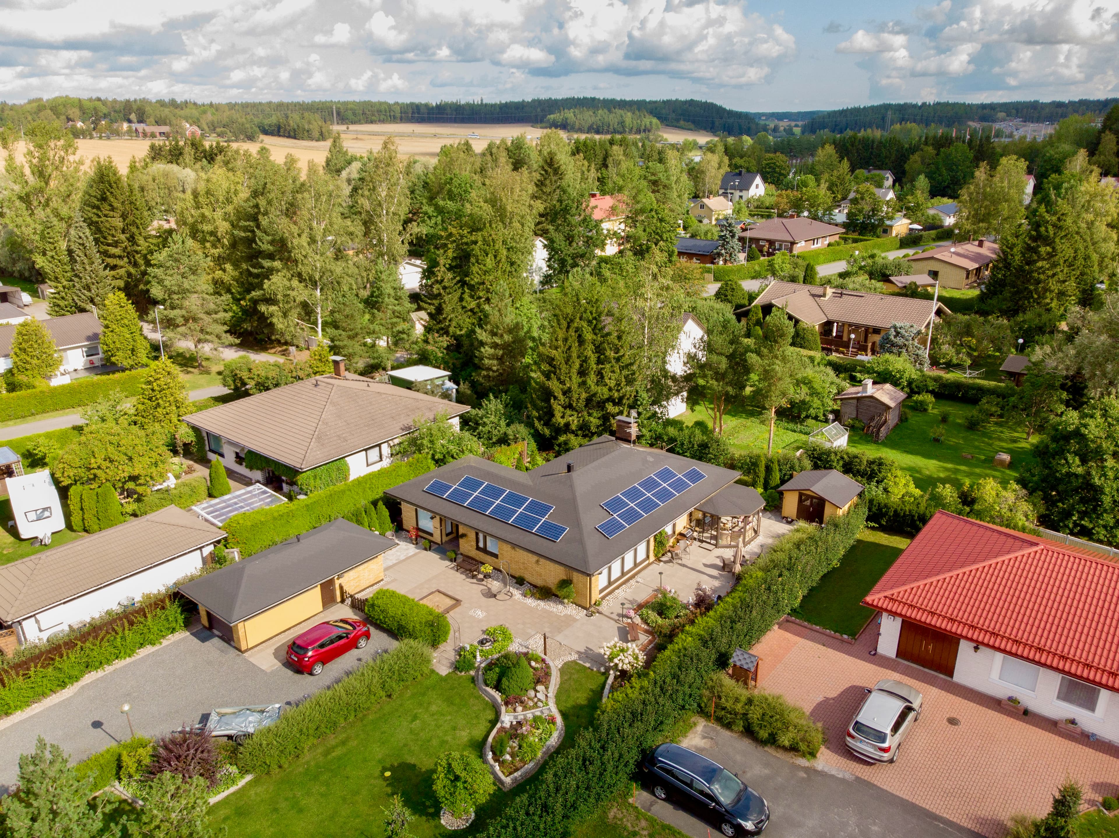 Kolme ihmistä 1KOMMA5°-näyttelytilassa, joka on sisustettu violetilla valaistuksella. Konsultti esittelee älypuhelinta kahdelle asiakkaalle – miehelle ja naiselle – keskustellen sen ominaisuuksista.